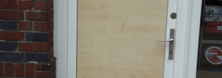 Haustür mit zerstörter Glasscheibe wurde mit einer Holzplatte gesichert.